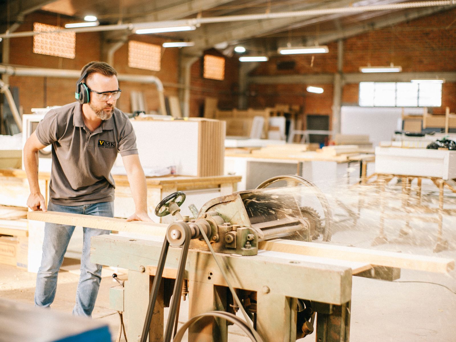 A local woodworker at his bench in a sunlit workshop — the kind of owner Hivetivity builds for.